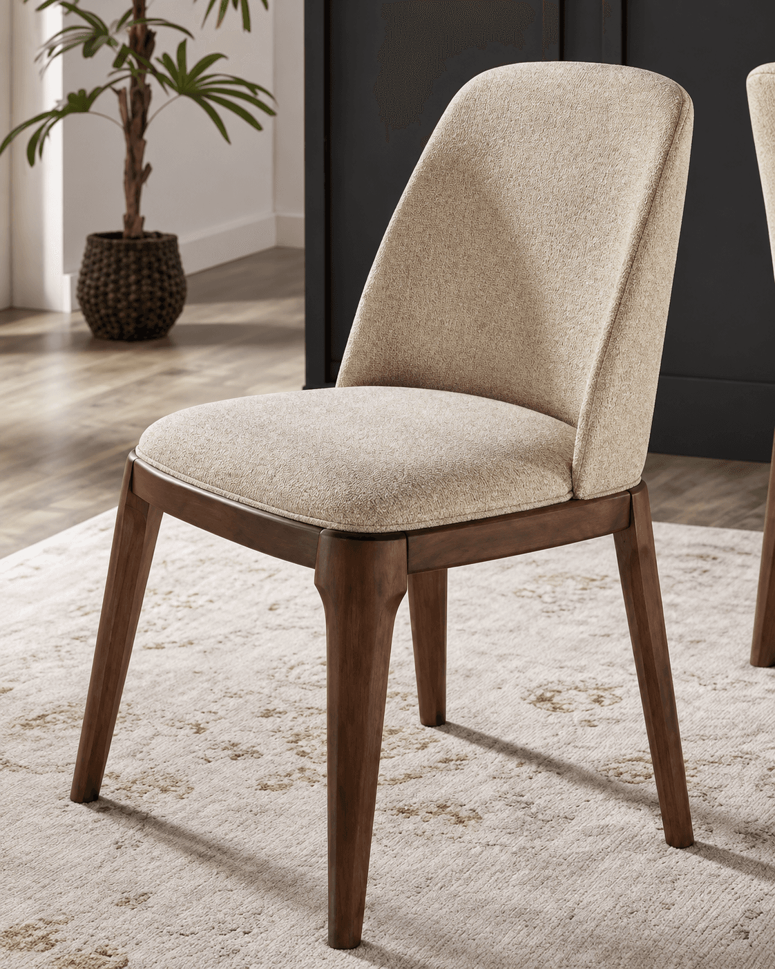MARA premium dining chair with a softly curved high upholstered back, cream seat and warm walnut wooden frame in an elegant interior.