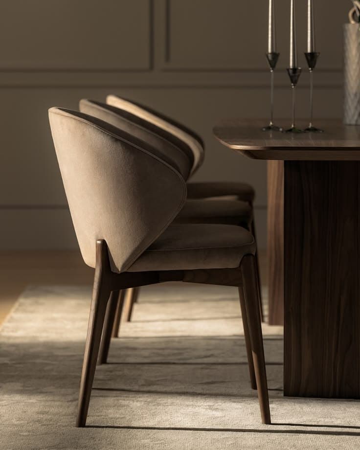 SELENE premium dining armchair with wraparound beige upholstered back, padded seat and dark walnut wooden frame in an elegant dining setting.