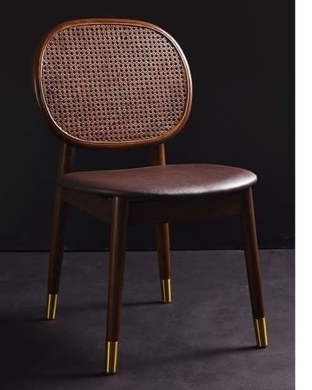 VIONA premium cane dining chair with a rounded cane backrest, upholstered seat, walnut frame and brass-gold foot caps in a dark interior.